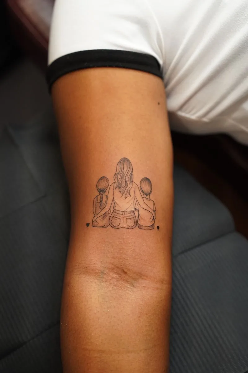 Tatuaje fine line: madre con sus dos hijos, en el brazo · Wilson Escobar, tatuador en Miami