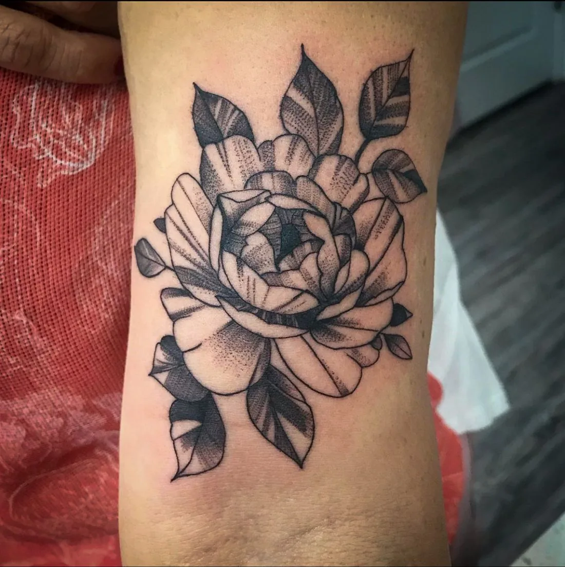 Tatuaje whipshading: flor grande con hojas, en el brazo · Wilson Escobar, tatuador en Miami