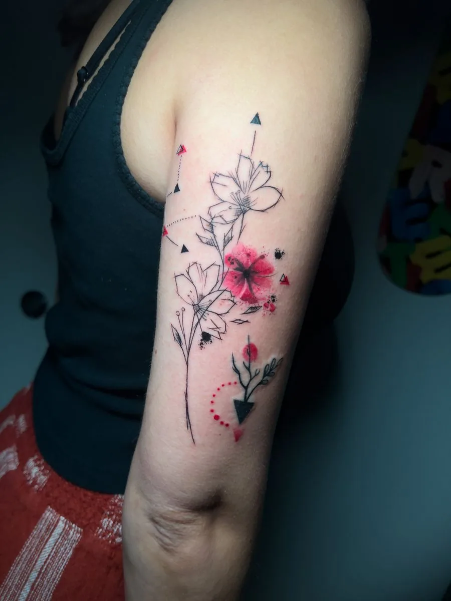 Tatuaje fine line con toques de color: flores y flechas, en el brazo · Wilson Escobar, tatuador en Miami