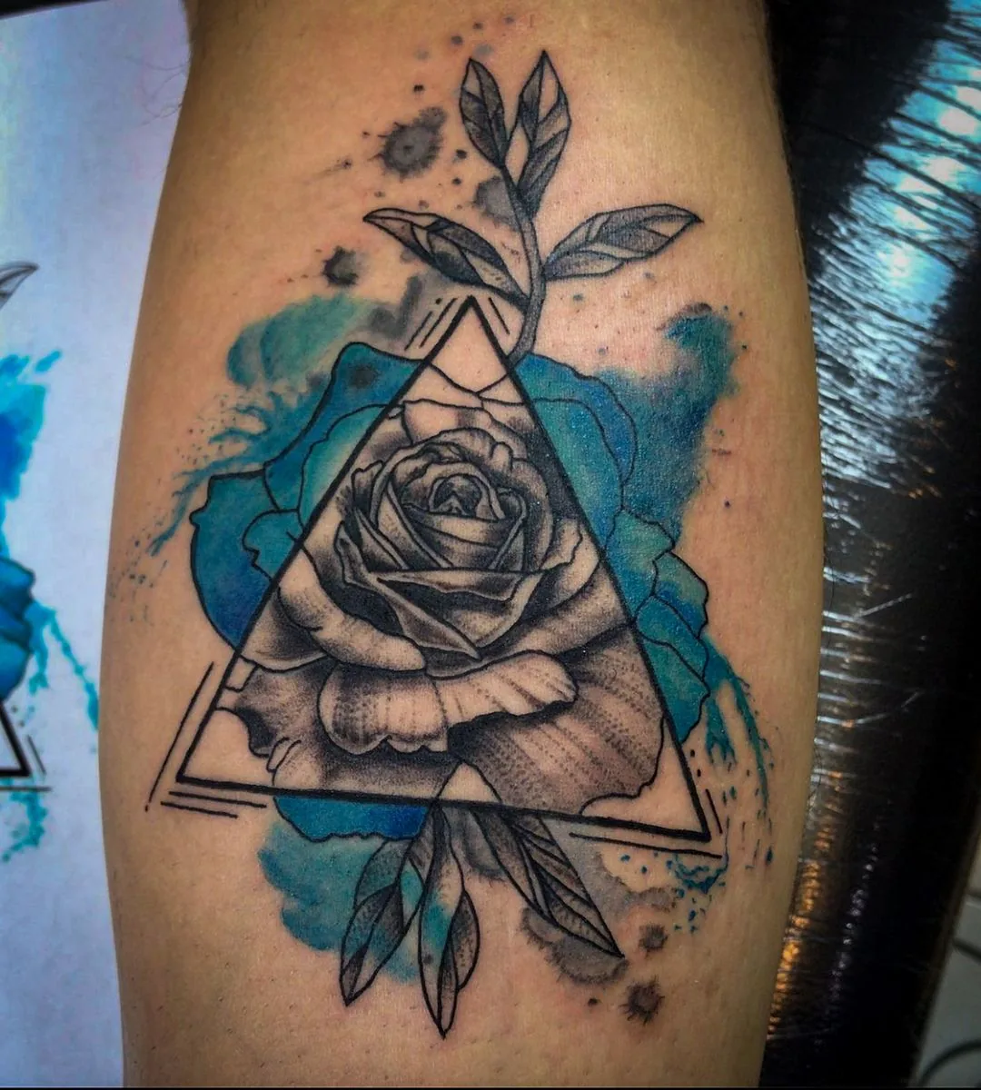 Tatuaje a color: rosa dentro de un triángulo con fondo de acuarela azul · Wilson Escobar, tatuador en Miami