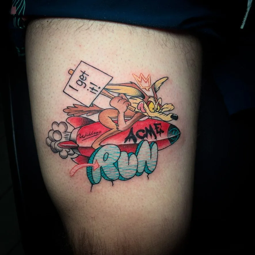 Tatuaje estilo parche bordado: personaje de caricatura sobre un cohete con letras «RUN», en la pierna · Wilson Escobar, tatuador en Miami